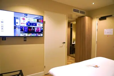 a room with a flat screen tv on the wall at HOTEL ALKMAAR - Bar & Restaurant - Meeting & Events in Alkmaar
