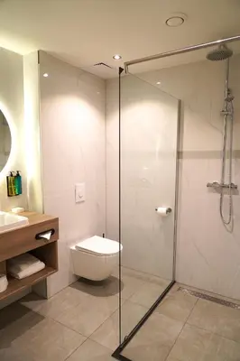 a bathroom with a toilet and a glass shower at HOTEL ALKMAAR - Bar & Restaurant - Meeting & Events in Alkmaar