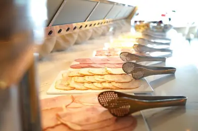 a buffet line with different types of food on plates at HOTEL ALKMAAR - Bar & Restaurant - Meeting & Events in Alkmaar