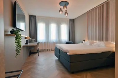a bedroom with a bed and a desk in a room at HOTEL ALKMAAR - Bar & Restaurant - Meeting & Events in Alkmaar