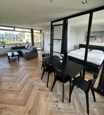 a living room with a table and a bed at @92 in Zandvoort
