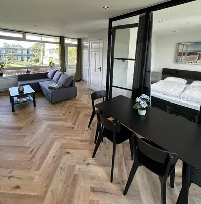 a living room with a table and a bed at @92 in Zandvoort