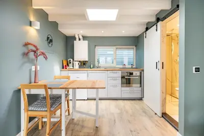 a kitchen with a wooden table and chairs at Studio Luxe 31 Zandvoort met gratis parkeerplaats in Zandvoort