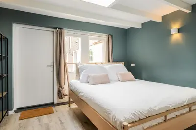 a bedroom with blue walls and a bed and a window at Studio Luxe 31 Zandvoort met gratis parkeerplaats in Zandvoort
