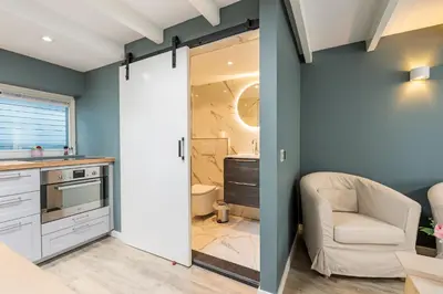 a kitchen with a sliding door leading into a bathroom at Studio Luxe 31 Zandvoort met gratis parkeerplaats in Zandvoort