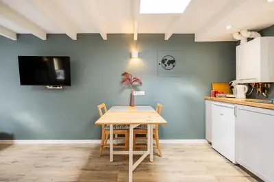 a kitchen and dining room with a table and chairs at Studio Luxe 31 Zandvoort met gratis parkeerplaats in Zandvoort