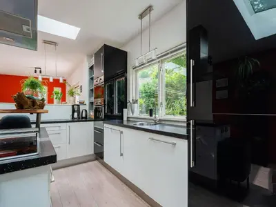 a kitchen with white cabinets and black appliances at Holiday house in Bergen with sauna in Bergen