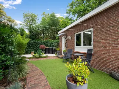 a yard with a brick house with a patio at Holiday house in Bergen with sauna in Bergen