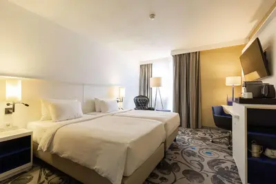a hotel room with a large bed and a television at Radisson Blu Hotel, Amsterdam City Center in Amsterdam