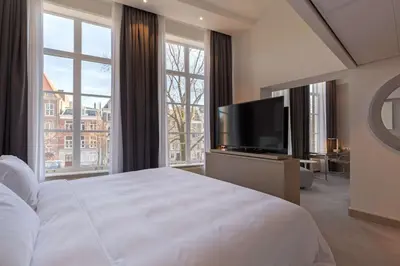 a bedroom with a large white bed and a large window at Radisson Blu Hotel, Amsterdam City Center in Amsterdam