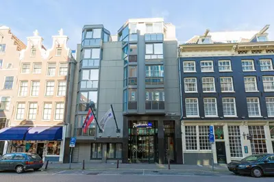 a tall building on a city street with buildings at Radisson Blu Hotel, Amsterdam City Center in Amsterdam