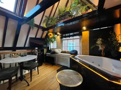 a room with a bath tub and a table and chairs at The smallest hotel in Amsterdam in Amsterdam