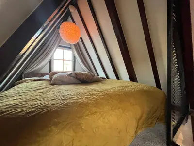 a bed in a room with a window at The smallest hotel in Amsterdam in Amsterdam