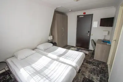 a bedroom with a large white bed in a room at Fletcher Hotel Restaurant Marijke in Bergen