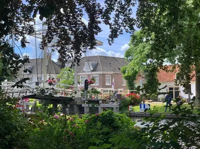 a bridge in front of a house with flowers at The Great Hideaway in Vreeland