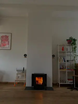 a living room with a fireplace and a chair at The Great Hideaway in Vreeland