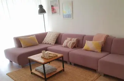 a purple couch in a living room with a table at 't Hoekhuisje in Katwijk aan Zee