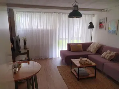 a living room with a purple couch and a table at 't Hoekhuisje in Katwijk aan Zee