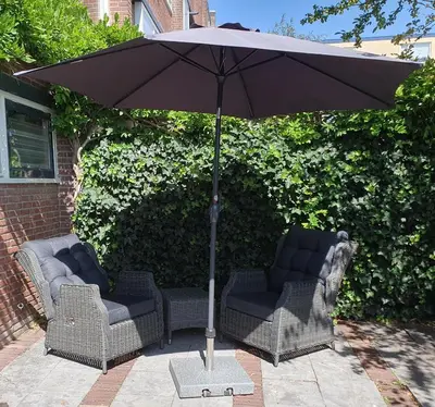 two chairs and an umbrella on a patio at 't Hoekhuisje in Katwijk aan Zee