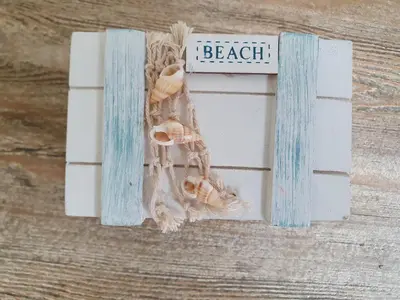 a beach sign with seashells and a sign that says beach at 't Hoekhuisje in Katwijk aan Zee