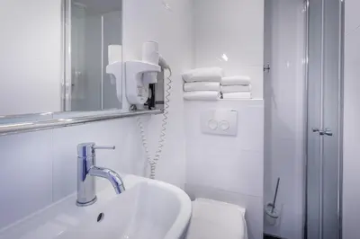 a bathroom with a sink and a toilet and a mirror at Hotel Victorie in Amsterdam