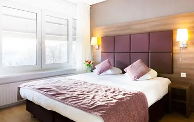 a bedroom with a large bed and a window at Hotel Victorie in Amsterdam