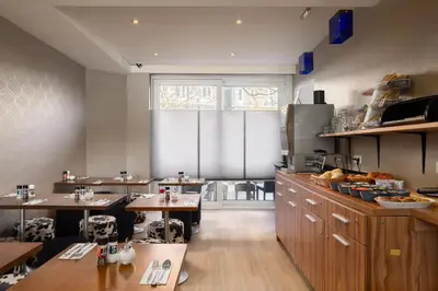a kitchen with wooden tables and a large window at Hotel Victorie in Amsterdam