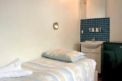 a small room with a bed and a sink at Hotel Torenzicht in Amsterdam