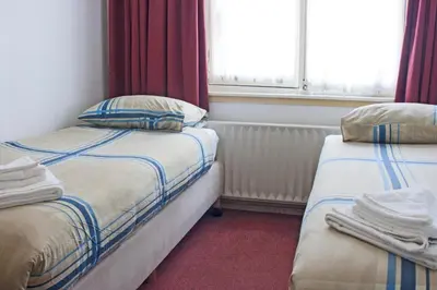 a room with two beds and a window at Hotel Torenzicht in Amsterdam