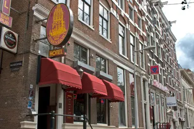 a brick building with red awnings on a street at Hotel Torenzicht in Amsterdam