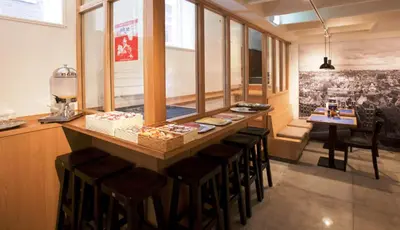 a restaurant with a bar with stools in a room at Hotel Torenzicht in Amsterdam