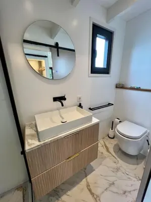 a bathroom with a sink and a toilet and a mirror at Surla Houseboat 