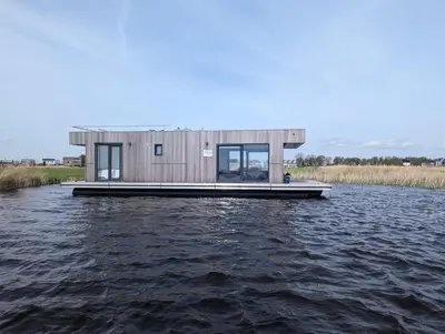 a house on a dock on a body of water at Surla Houseboat 