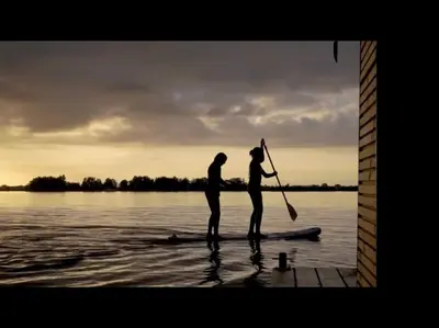 two people standing on a paddle board in the water at Surla Houseboat 