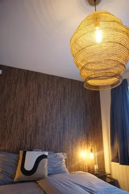 a bedroom with a bed and a large chandelier at Bed and Breakfast Kik en Bun in Katwijk aan Zee