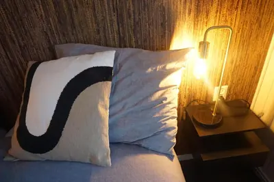 a bed with a pillow with a c on it at Bed and Breakfast Kik en Bun in Katwijk aan Zee