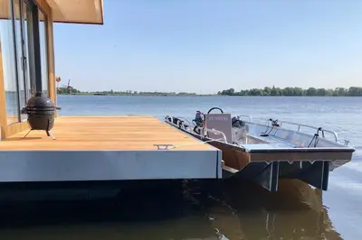 a boat on the water next to a dock at Surla houseboat 