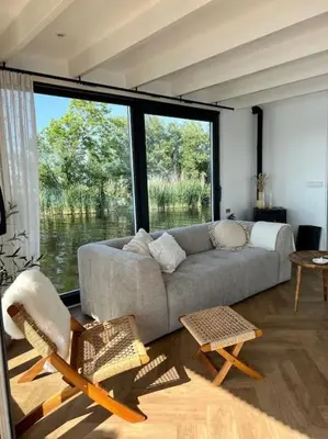a living room with a couch and a large window at Surla houseboat 