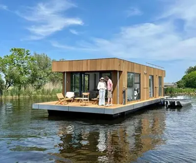 a tiny house on a dock on a body of water at Surla houseboat 