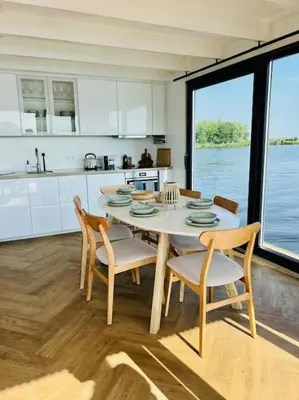 a kitchen with a table and chairs and a kitchen with water at Surla houseboat 