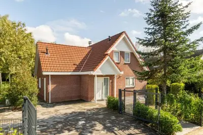a brick house with a gate and a fence at Modern Luxury villa in Zeewolde