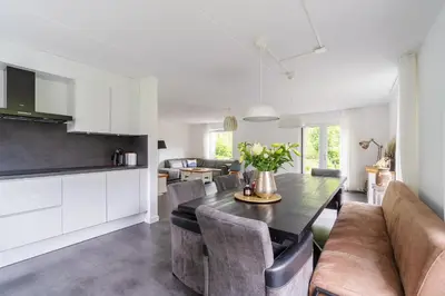 a kitchen and living room with a table and chairs at Modern Luxury villa in Zeewolde