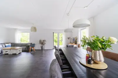 a living room with a long table and a couch at Modern Luxury villa in Zeewolde