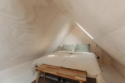 a bedroom with a bed and a wooden table at Studio Verver in Bergen