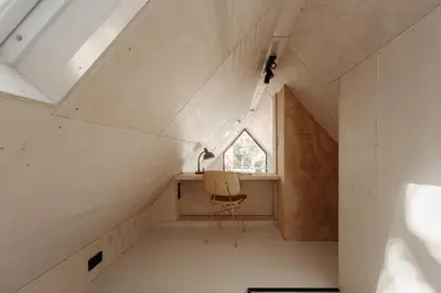 a room with a window and a chair in a attic at Studio Verver in Bergen