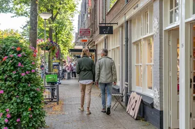 two people walking down a sidewalk down a street at Studio Verver in Bergen