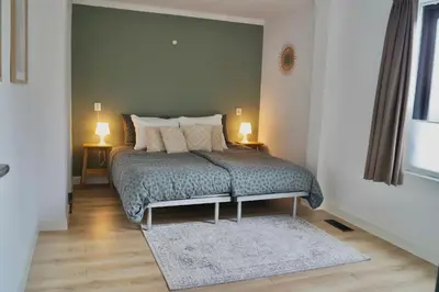 a bedroom with a bed with a green wall at Vakantiehuis 't Hofje nabij dorpscentrum en strand in Castricum