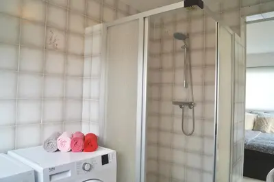 a bathroom with a shower with pink and red towels at Vakantiehuis 't Hofje nabij dorpscentrum en strand in Castricum