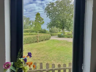 a window with a view of a yard at Vakantiehuis 't Hofje nabij dorpscentrum en strand in Castricum