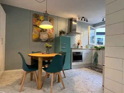 a kitchen with a table and chairs and a blue refrigerator at The Coast Beach House in Egmond aan Zee